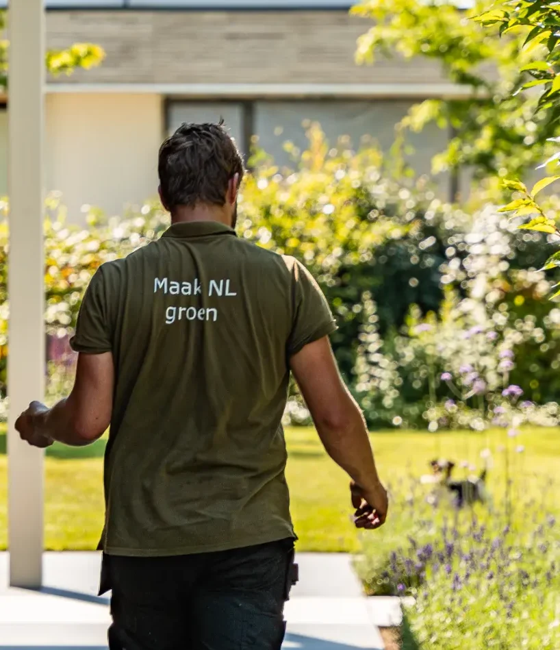 Hovenier met het shirt Maak Nederland Groen in de tuin die Uw Tuin Hoveniers heeft aangelegd.